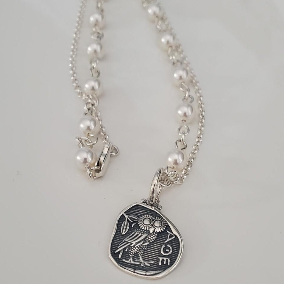 Necklace with a silver pendant featuring an owl design on a light gray background