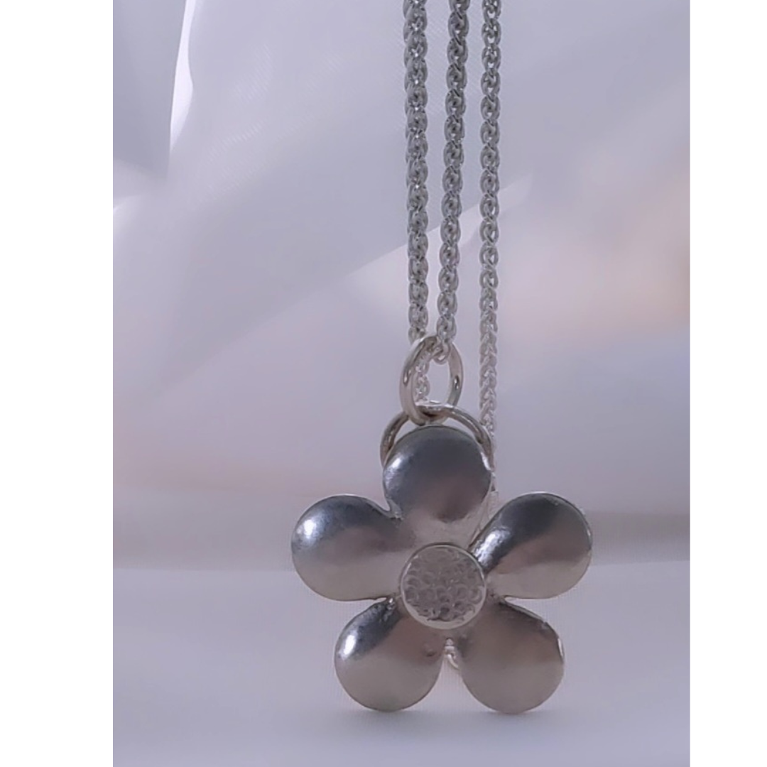 My Sterling Silver Ups a Daisy Necklace embodies rejuvenation, renewal, and authenticity. With its springtime charm and timeless beauty, the daisy symbolizes hope, confidence, and strength. This distinctive Plein De Vie piece is a delightful nod to sixties flower power, blooming eternally to remind you to stand up for your values and stay true to yourself.