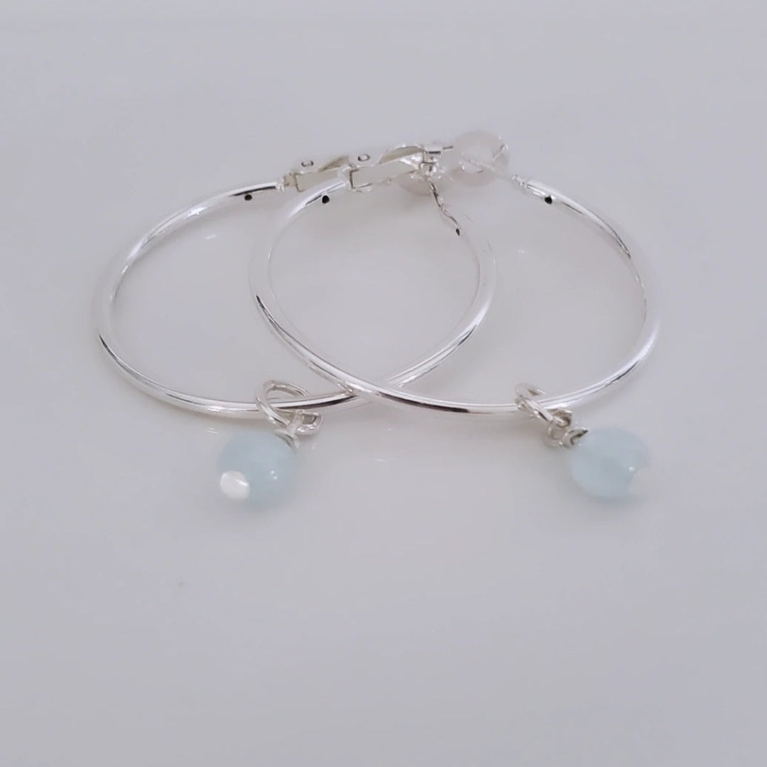 Introducing exquisite 6mm Genuine Round Aquamarine Sterling Silver Hoop Charms. Showcasing serene blue aquamarine gemstones set in sterling silver, these charms offer timeless sophistication and versatility. Perfect for everyday wear or special occasions, they add ethereal beauty and a touch of serenity to any jewelry collection.