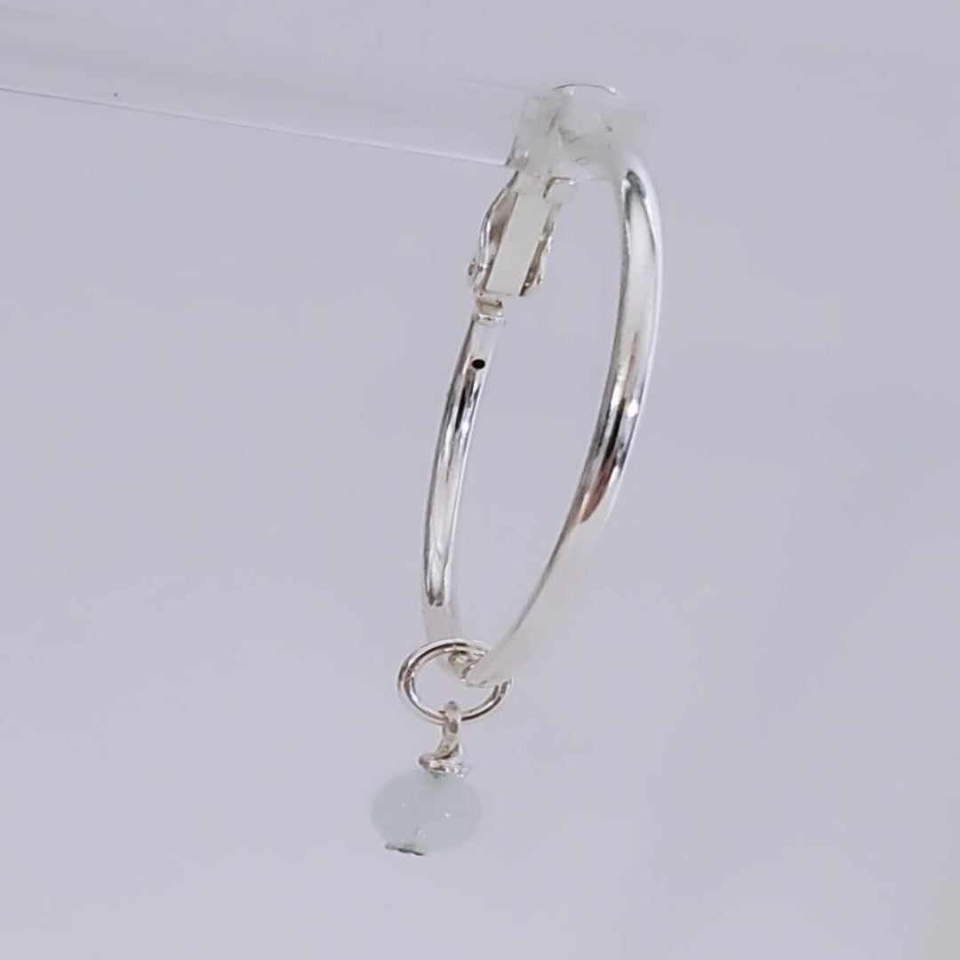 Introducing exquisite 6mm Genuine Round Aquamarine Sterling Silver Hoop Charms. Showcasing serene blue aquamarine gemstones set in sterling silver, these charms offer timeless sophistication and versatility. Perfect for everyday wear or special occasions, they add ethereal beauty and a touch of serenity to any jewelry collection.