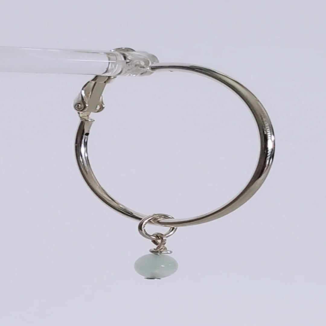 Introducing exquisite 6mm Genuine Round Aquamarine Sterling Silver Hoop Charms. Showcasing serene blue aquamarine gemstones set in sterling silver, these charms offer timeless sophistication and versatility. Perfect for everyday wear or special occasions, they add ethereal beauty and a touch of serenity to any jewelry collection.