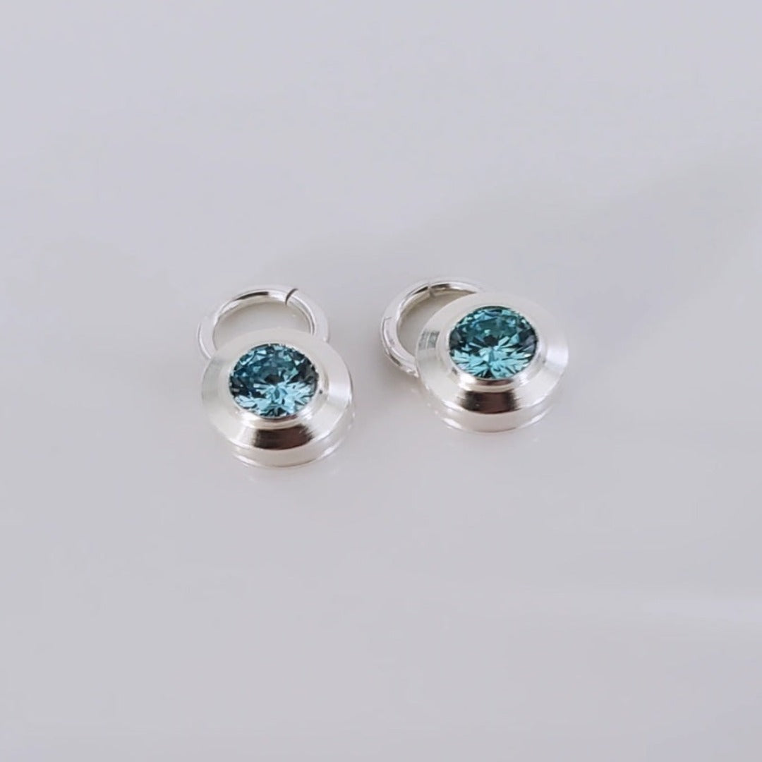 Introducing elegant 4mm Aquamarine and Peridot Sterling Silver Bezel Set Hoop Charms. Featuring genuine aquamarine and peridot gemstones, these charms add sophistication and natural beauty to any ensemble. With serene blue and vibrant green hues, they offer a timeless yet modern appeal. Perfect for elevating everyday style with a touch of elegance.