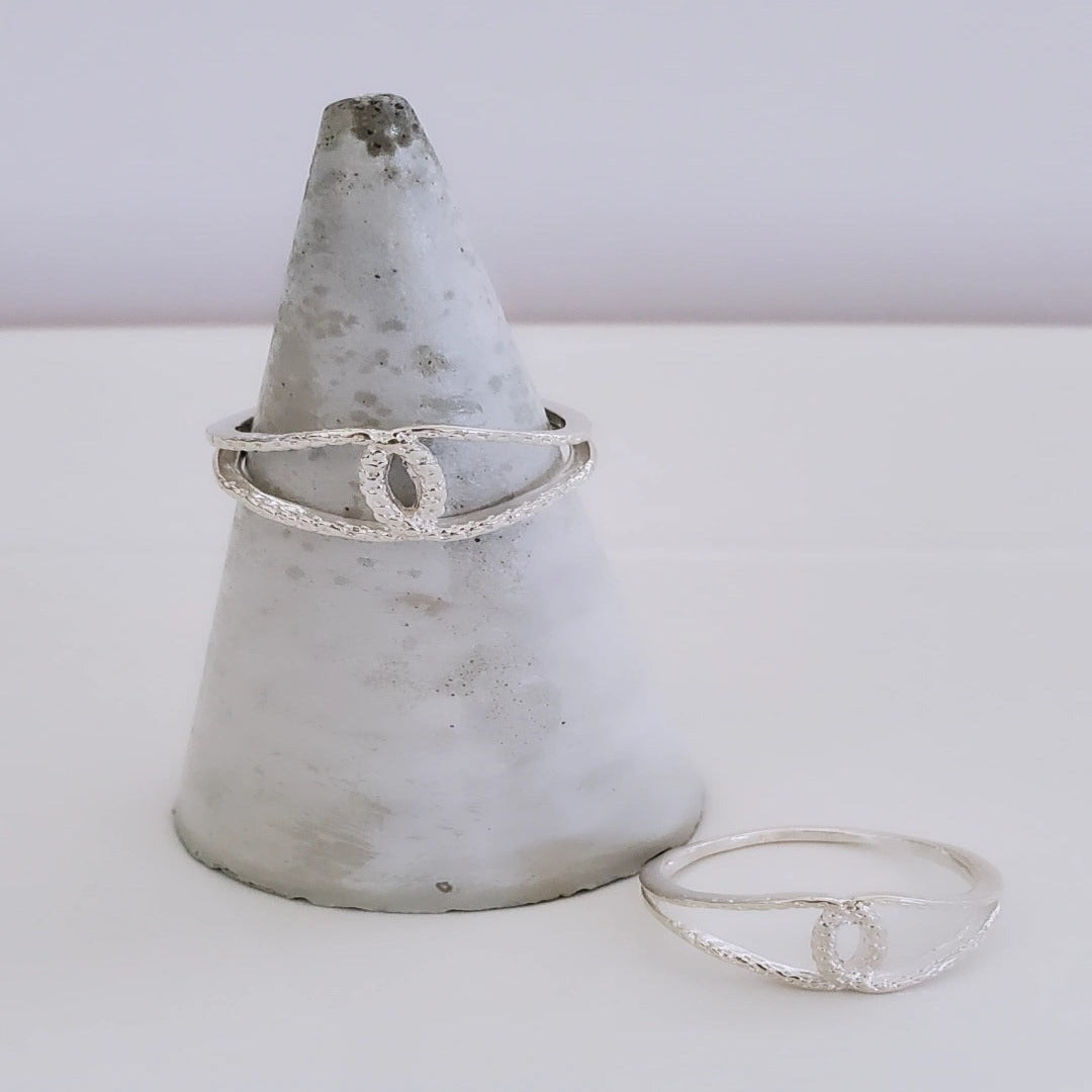 Harmony Hammered Sterling Silver Ring with overlapping loops, symbolizing balance and elegance. Features a hammered texture for unique visual interest. Versatile and timeless, this ring can be worn alone or stacked, making it a perfect everyday accessory for any outfit.