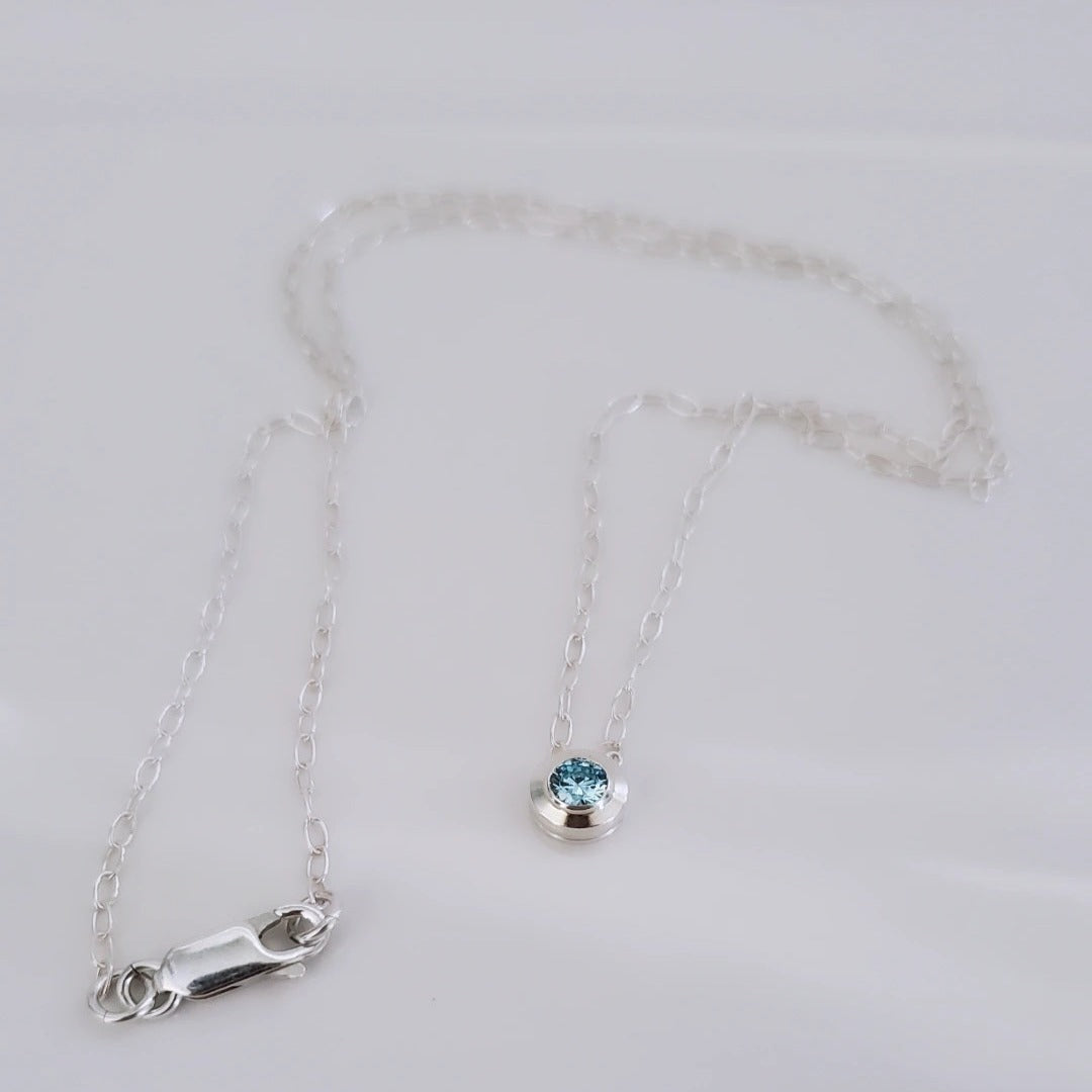 Picture of Harmony Gems Crystal Necklaces featuring genuine aquamarine or peridot crystals set in sterling silver bezels. These necklaces symbolize harmony and balance, reflecting the natural beauty and tranquility of the earth. The serene blue hues of aquamarine complement the vibrant green tones of peridot, symbolizing growth and renewal. Perfect for those seeking inner peace and connection to the world around them.