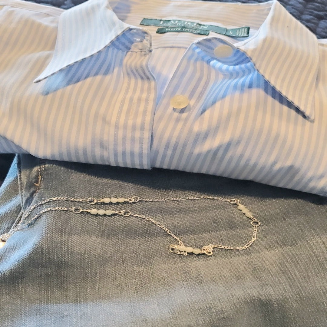 Picture of Aqua Serenity Sterling Silver Figaro Necklace. This necklace features a 2.2mm Modern Figaro style with genuine 4mm aquamarine gemstones interspersed in sets of three. Its minimalistic design exudes understated elegance, perfect for layering or wearing solo. Adjustable length of 17 inches plus a 2 inch extension allows for a customized fit.
