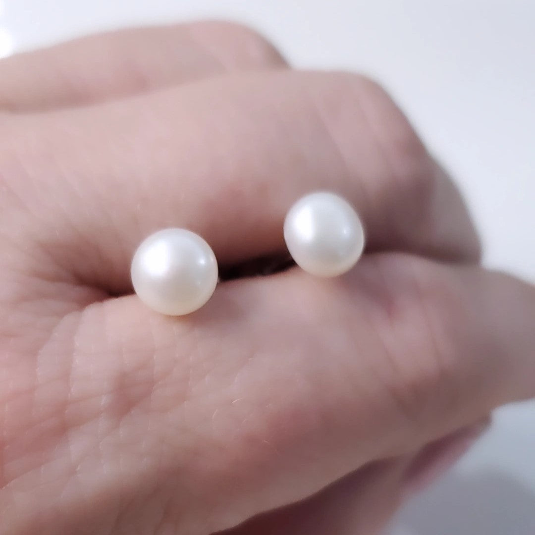 Eternal Elegance Pearl Studs featuring 8mm freshwater pearls on sterling silver rhodium plated posts. These classic earrings blend sophistication with versatility, perfect for any occasion. The pristine pearls capture light beautifully, enhancing natural radiance. Crafted with love and quality, they celebrate timeless beauty and life's special moments.
