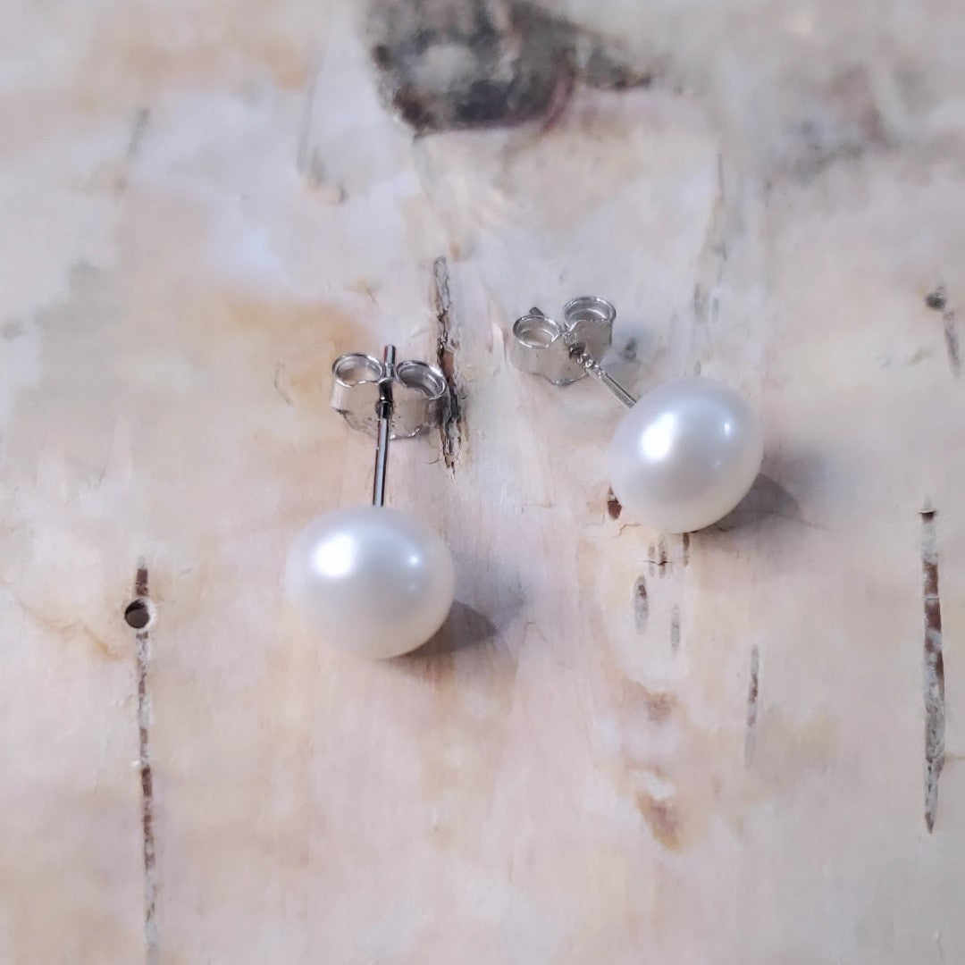 Eternal Elegance Pearl Studs featuring 8mm freshwater pearls on sterling silver rhodium plated posts. These classic earrings blend sophistication with versatility, perfect for any occasion. The pristine pearls capture light beautifully, enhancing natural radiance. Crafted with love and quality, they celebrate timeless beauty and life's special moments.