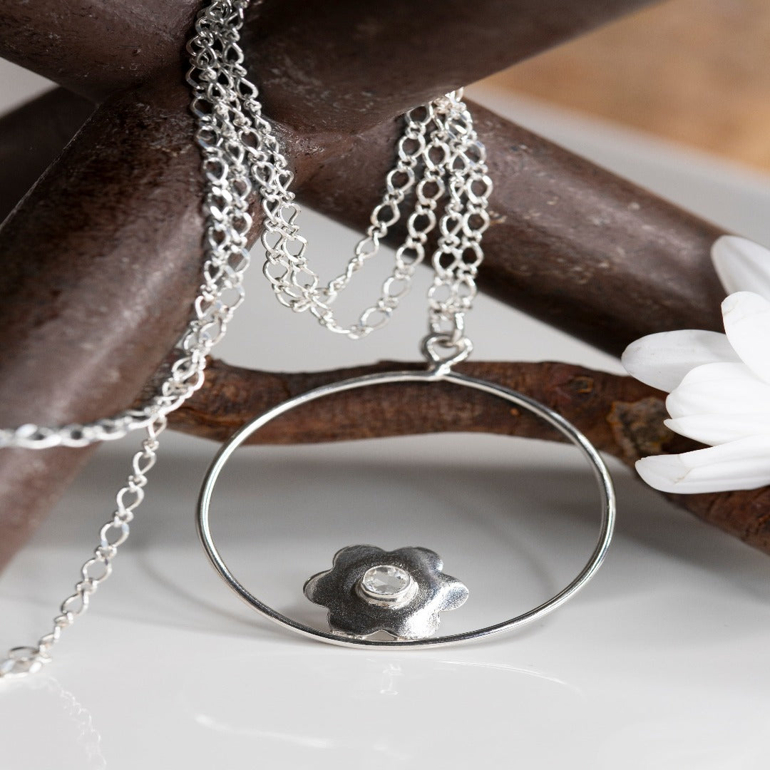 My Sterling Silver Twisted Cable Oval Figure 8 Chain with 1.5" Circle and Flower Pendant is a timeless classic. Ideal for those who appreciate a minimal look and have a love for flowers, this piece can be worn solo or layered with your favorite Plein De Vie jewelry. Daisies, a symbol of joy, inspire this design. Wrap your neck in a little joy and let it brighten your day!