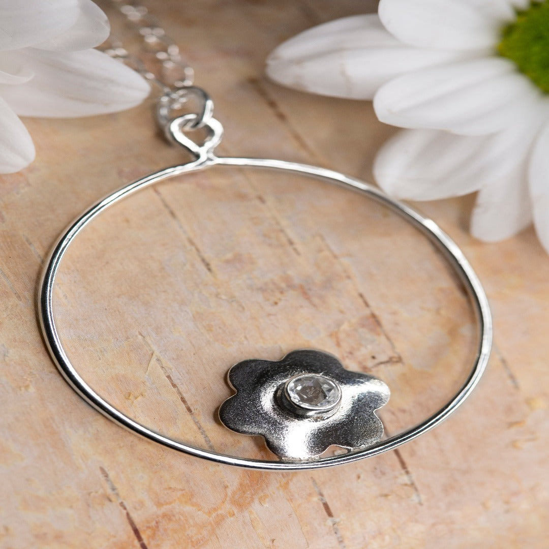 My Sterling Silver Twisted Cable Oval Figure 8 Chain with 1.5" Circle and Flower Pendant is a timeless classic. Ideal for those who appreciate a minimal look and have a love for flowers, this piece can be worn solo or layered with your favorite Plein De Vie jewelry. Daisies, a symbol of joy, inspire this design. Wrap your neck in a little joy and let it brighten your day!