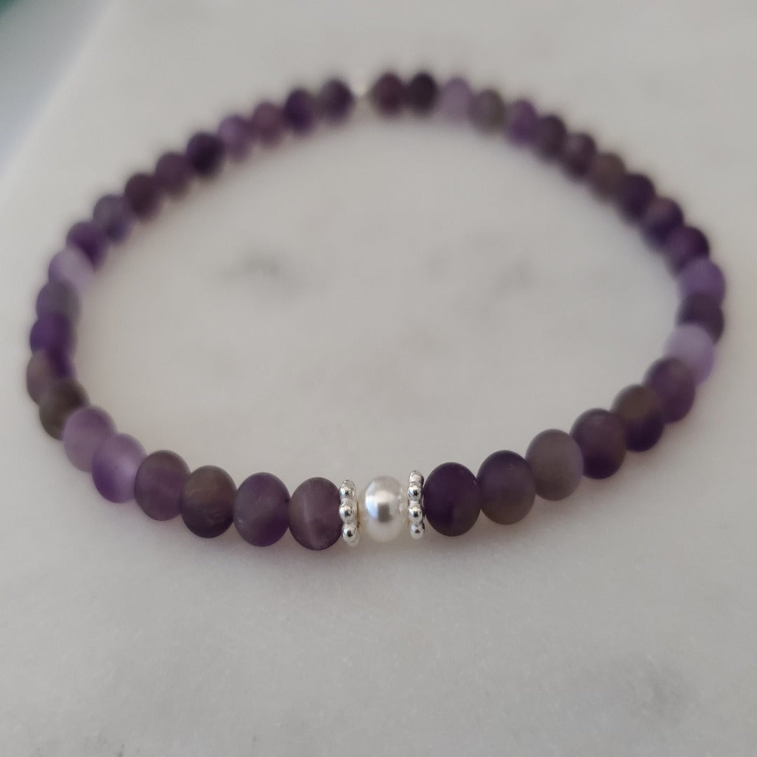 Introducing my Expandable 4mm Amethyst Gemstone Soothing Bracelet, a blend of elegance and calm. Featuring 4mm Amethyst gemstones for relaxation, Sterling Silver daisy spacers, and a 4mm Swarovski White Pearl for added grace. Wear it solo or mix and match with other Plein De Vie Jewelry bracelets to create your unique stack. Elevate your style and embrace tranquility with this exquisite piece.