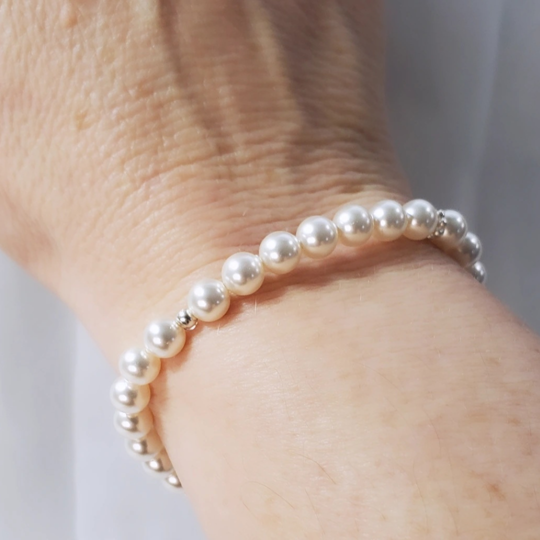 Swarovski Pearl and Daisy Bracelet symbolizing Mother Nature’s nurturing and protection. Features daisy spacers reminiscent of Spring wildflowers, creating a timeless and classic look. Can be worn solo or layered with other Plein De Vie favorites.