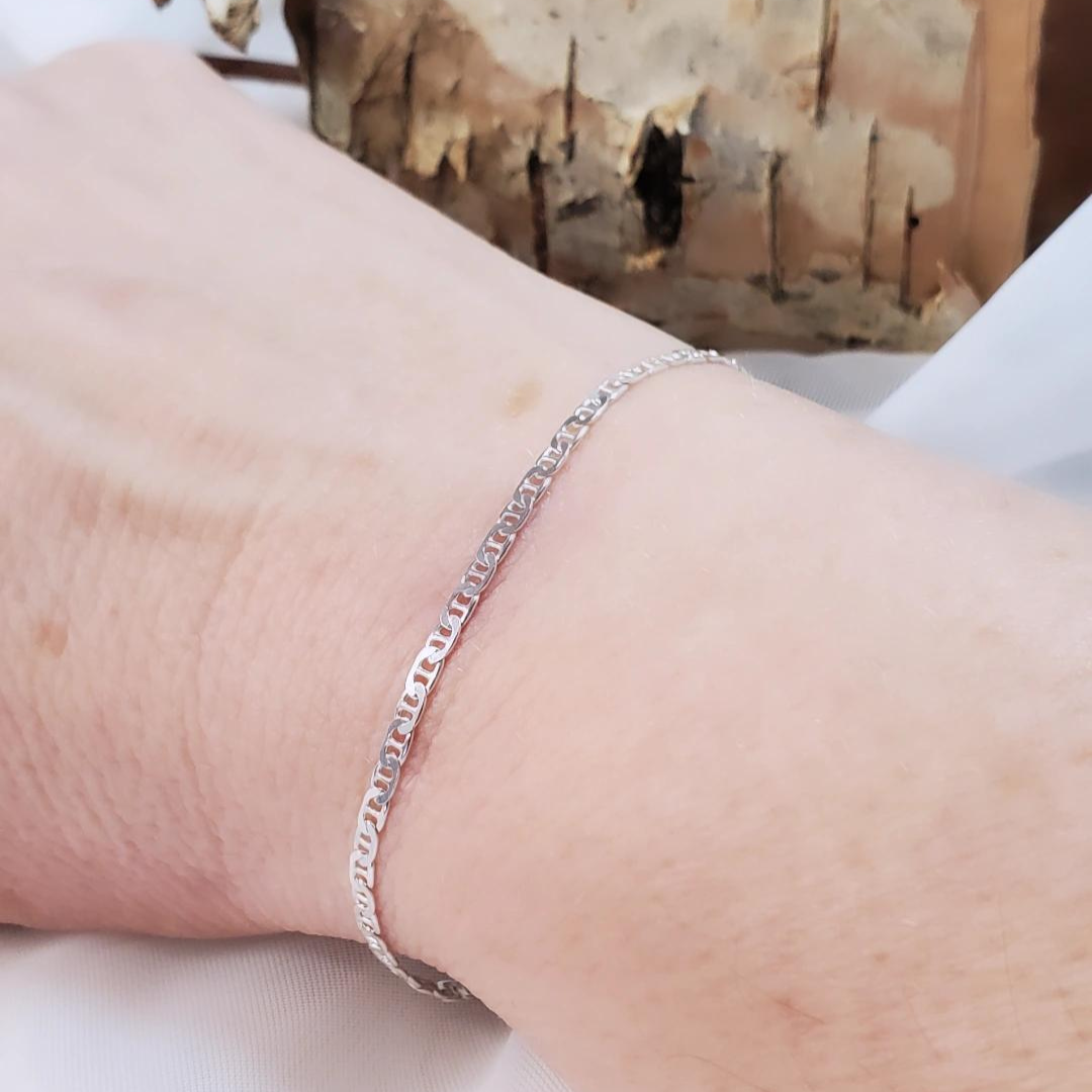 Introducing my Sterling Silver Half Flat Oval Mariner Curb Bracelet, a timeless 7-inch piece exuding elegance and charm. Crafted with half flat oval links and a double heart charm, it adds a touch of love and sophistication. Wear it solo or layered with other Plein De Vie Jewelry bracelets for a unique style. Elevate your look with this versatile bracelet from Plein De Vie Jewelry.