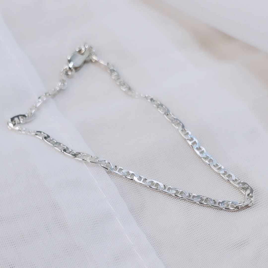 Introducing my Sterling Silver Half Flat Oval Mariner Curb Bracelet, a timeless 7-inch piece exuding elegance and charm. Crafted with half flat oval links and a double heart charm, it adds a touch of love and sophistication. Wear it solo or layered with other Plein De Vie Jewelry bracelets for a unique style. Elevate your look with this versatile bracelet from Plein De Vie Jewelry.