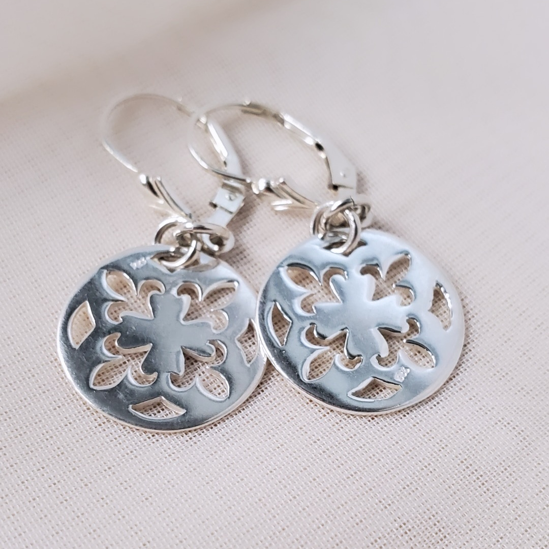 Introducing my Sterling Silver Leverback Fleur-de-lis Luxe Earrings: elegant and symbolic with a cut-out fleur-de-lis in a circle design. With a secure leverback closure, these earrings are inspired by French royalty, adding sophistication to any outfit. Perfect for both casual outings and formal events, they embody timeless elegance and cultural significance.