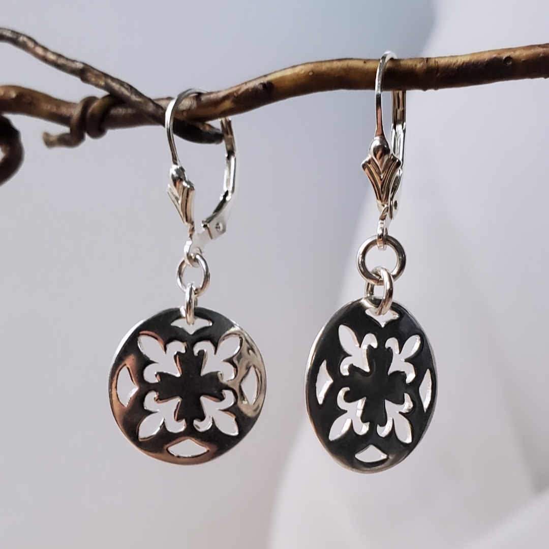 Introducing my Sterling Silver Leverback Fleur-de-lis Luxe Earrings: elegant and symbolic with a cut-out fleur-de-lis in a circle design. With a secure leverback closure, these earrings are inspired by French royalty, adding sophistication to any outfit. Perfect for both casual outings and formal events, they embody timeless elegance and cultural significance.