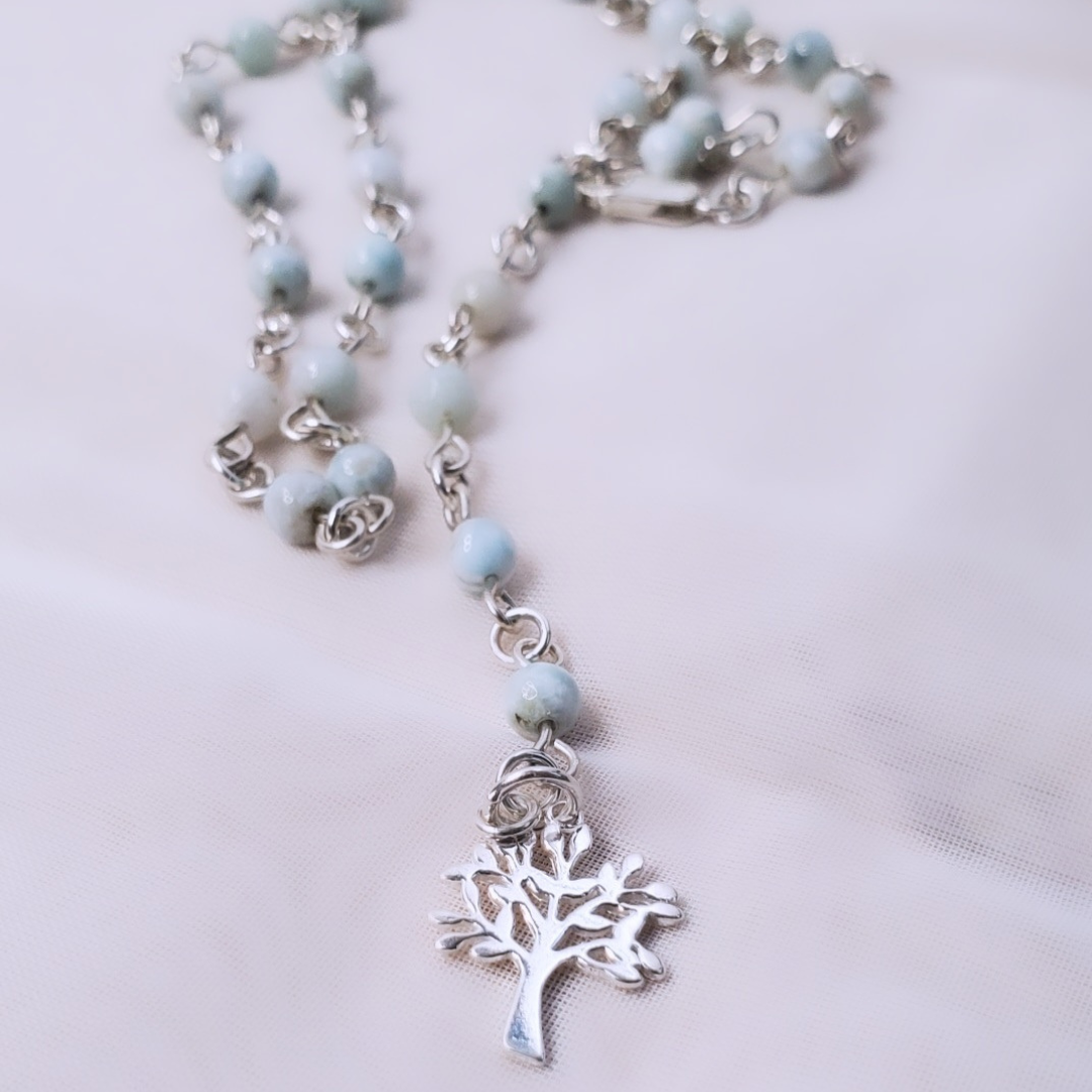 Picture of Sterling Silver Larimarvelous Necklace featuring a sterling silver tree pendant and gentle-energy larimar gemstones. This necklace symbolizes higher wisdom, healing, and manifestation, while larimar promotes a natural state of vitality and connection with nature.