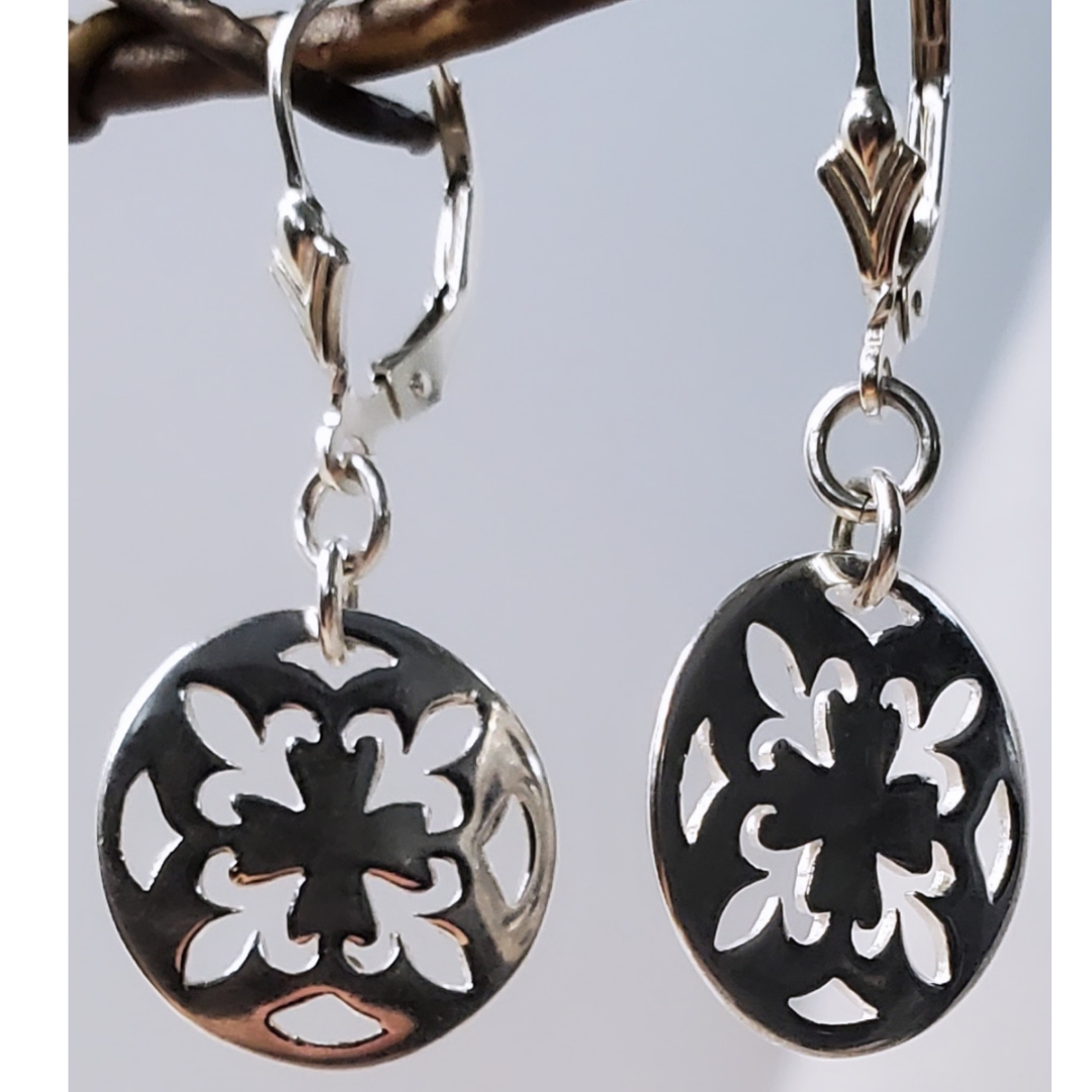 Introducing my Sterling Silver Leverback Fleur-de-lis Luxe Earrings: elegant and symbolic with a cut-out fleur-de-lis in a circle design. With a secure leverback closure, these earrings are inspired by French royalty, adding sophistication to any outfit. Perfect for both casual outings and formal events, they embody timeless elegance and cultural significance.