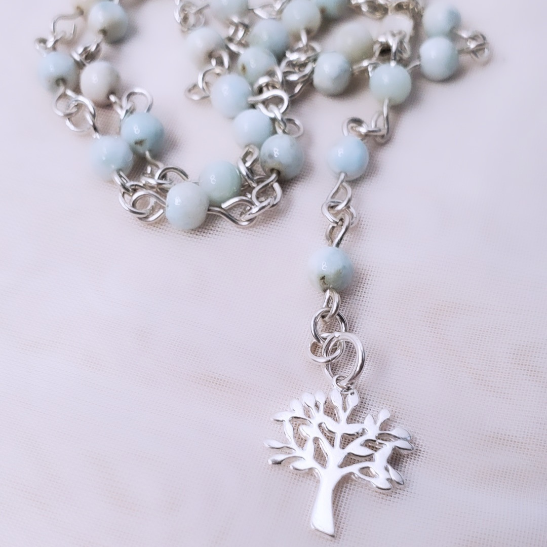 Picture of Sterling Silver Larimarvelous Necklace featuring a sterling silver tree pendant and gentle-energy larimar gemstones. This necklace symbolizes higher wisdom, healing, and manifestation, while larimar promotes a natural state of vitality and connection with nature.