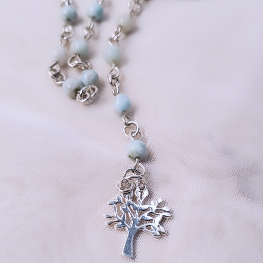 Picture of Sterling Silver Larimarvelous Necklace featuring a sterling silver tree pendant and gentle-energy larimar gemstones. This necklace symbolizes higher wisdom, healing, and manifestation, while larimar promotes a natural state of vitality and connection with nature.