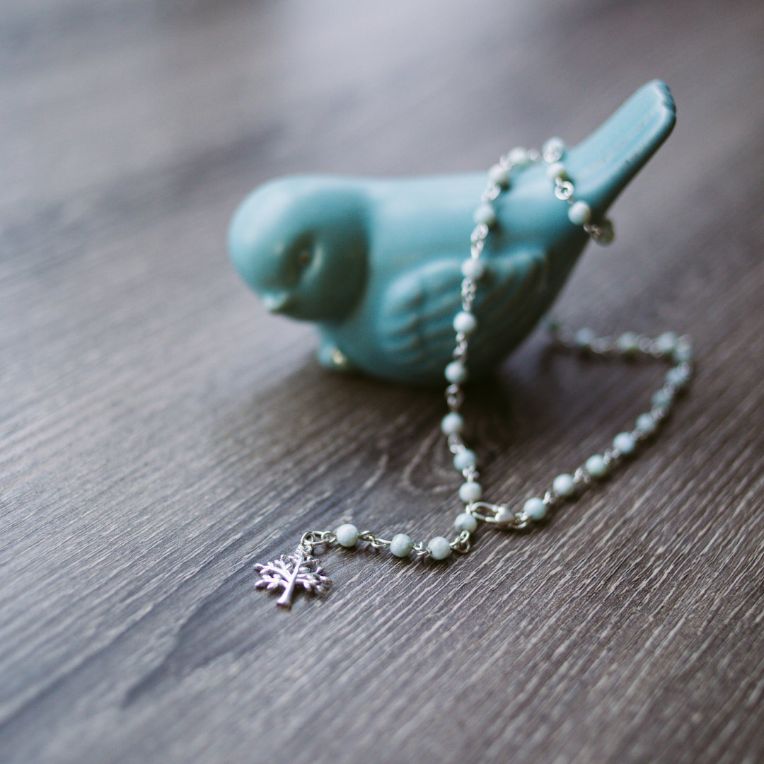 Picture of Sterling Silver Larimarvelous Necklace featuring a sterling silver tree pendant and gentle-energy larimar gemstones. This necklace symbolizes higher wisdom, healing, and manifestation, while larimar promotes a natural state of vitality and connection with nature.
