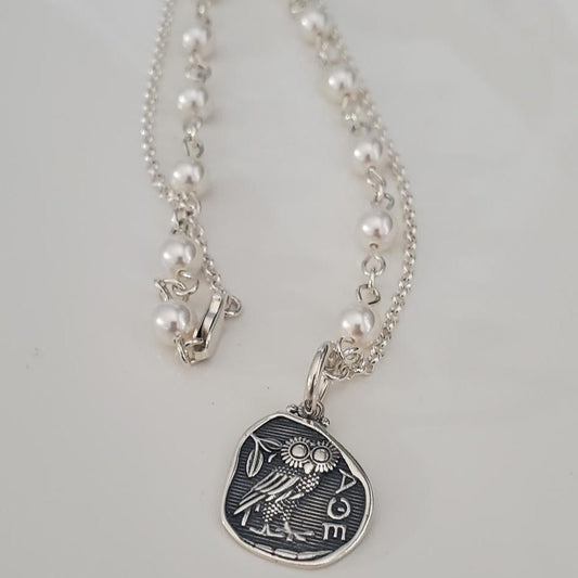 Necklace with a silver pendant featuring an owl design on a light gray background