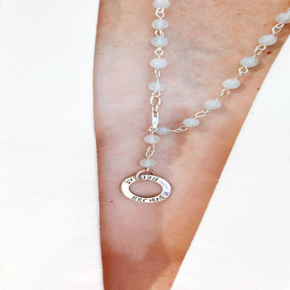 Picture of the handmade Sterling Silver Aquamarine Necklace "BELIEVE." This 31" necklace features genuine aquamarine round gemstones linked with 20g sterling silver, secured with a lobster clasp. The washer-style pendant stamped with "BELIEVE" adds a meaningful touch, symbolizing authenticity, growth, love, inspiration, education, integrity, and joy. Wear it as a regular necklace or transform it into a lariat style to accentuate your style and remind yourself of these powerful principles.