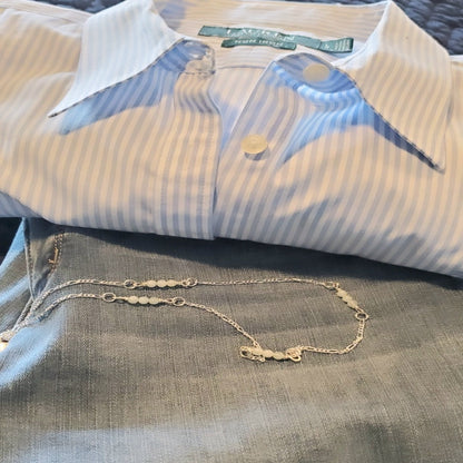 Picture of Aqua Serenity Sterling Silver Figaro Necklace. This necklace features a 2.2mm Modern Figaro style with genuine 4mm aquamarine gemstones interspersed in sets of three. Its minimalistic design exudes understated elegance, perfect for layering or wearing solo. Adjustable length of 17 inches plus a 2 inch extension allows for a customized fit.