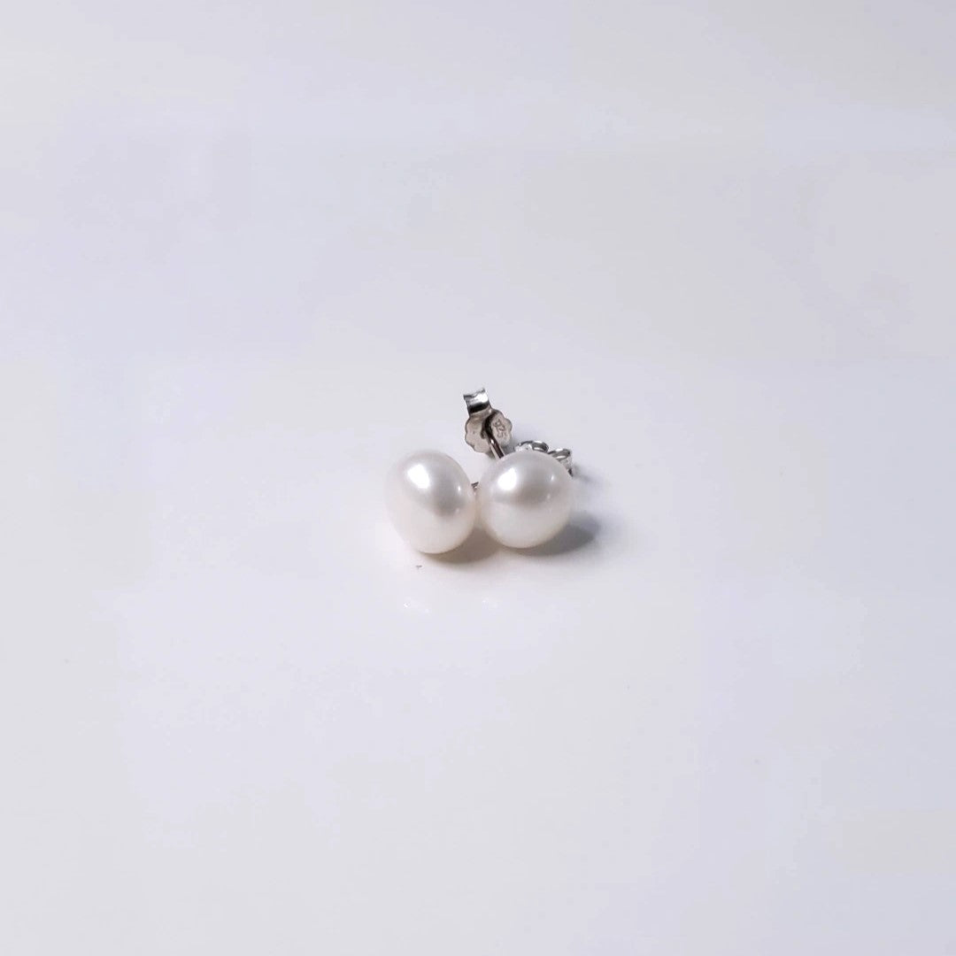 Eternal Elegance Pearl Studs featuring 8mm freshwater pearls on sterling silver rhodium plated posts. These classic earrings blend sophistication with versatility, perfect for any occasion. The pristine pearls capture light beautifully, enhancing natural radiance. Crafted with love and quality, they celebrate timeless beauty and life's special moments.