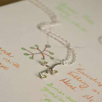 Image of a Sterling Silver Spring Tree Bud Branch Necklace, symbolizing power, durability, and perpetual growth. Inspired by John Muir's quote, "I venture into the forest, to release my thoughts and discover my inner self," this necklace represents a deep connection to nature and the endless possibilities that lie ahead. The design features intricately crafted branches extending upwards, capturing the essence of growth and resilience.