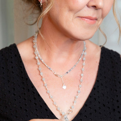 Picture of the handmade Sterling Silver Aquamarine Necklace "BELIEVE." This 31" necklace features genuine aquamarine round gemstones linked with 20g sterling silver, secured with a lobster clasp. The washer-style pendant stamped with "BELIEVE" adds a meaningful touch, symbolizing authenticity, growth, love, inspiration, education, integrity, and joy. Wear it as a regular necklace or transform it into a lariat style to accentuate your style and remind yourself of these powerful principles.