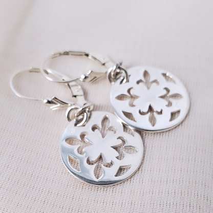 Introducing my Sterling Silver Leverback Fleur-de-lis Luxe Earrings: elegant and symbolic with a cut-out fleur-de-lis in a circle design.  With a secure leverback closure, these earrings are inspired by French royalty, adding sophistication to any outfit. Perfect for both casual outings and formal events, they embody timeless elegance and cultural significance.