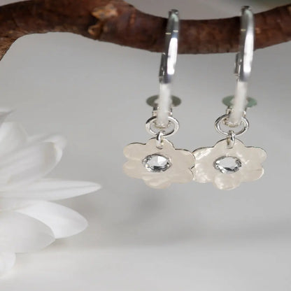 Sterling Silver Hoop Moodmaker Earrings featuring daisy charms and Swarovski crystal cubic zirconia flatbacks. These versatile earrings offer two looks in one with removable charms. The classic hoop design is perfect for everyday wear or special occasions, adding a touch of elegance and joy to your look.